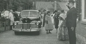 Mijlpaal: het Nederlands Openluchtmuseum bestaat een eeuw! Aankomst van prinses Wilhelmina in het Nederlands Openluchtmuseum. In de Tweede Wereldoorlog is de streekdrachtencollectie vrijwel geheel verloren gegaan. Na de oorlog werd een nieuwe collectie verzameld; deze werd aangeboden aan prinses Wilhelmina. Zij heeft deze collectie in permanente bruikleen gegeven aan het museum. Foto: Nederlands Openluchtmuseum.