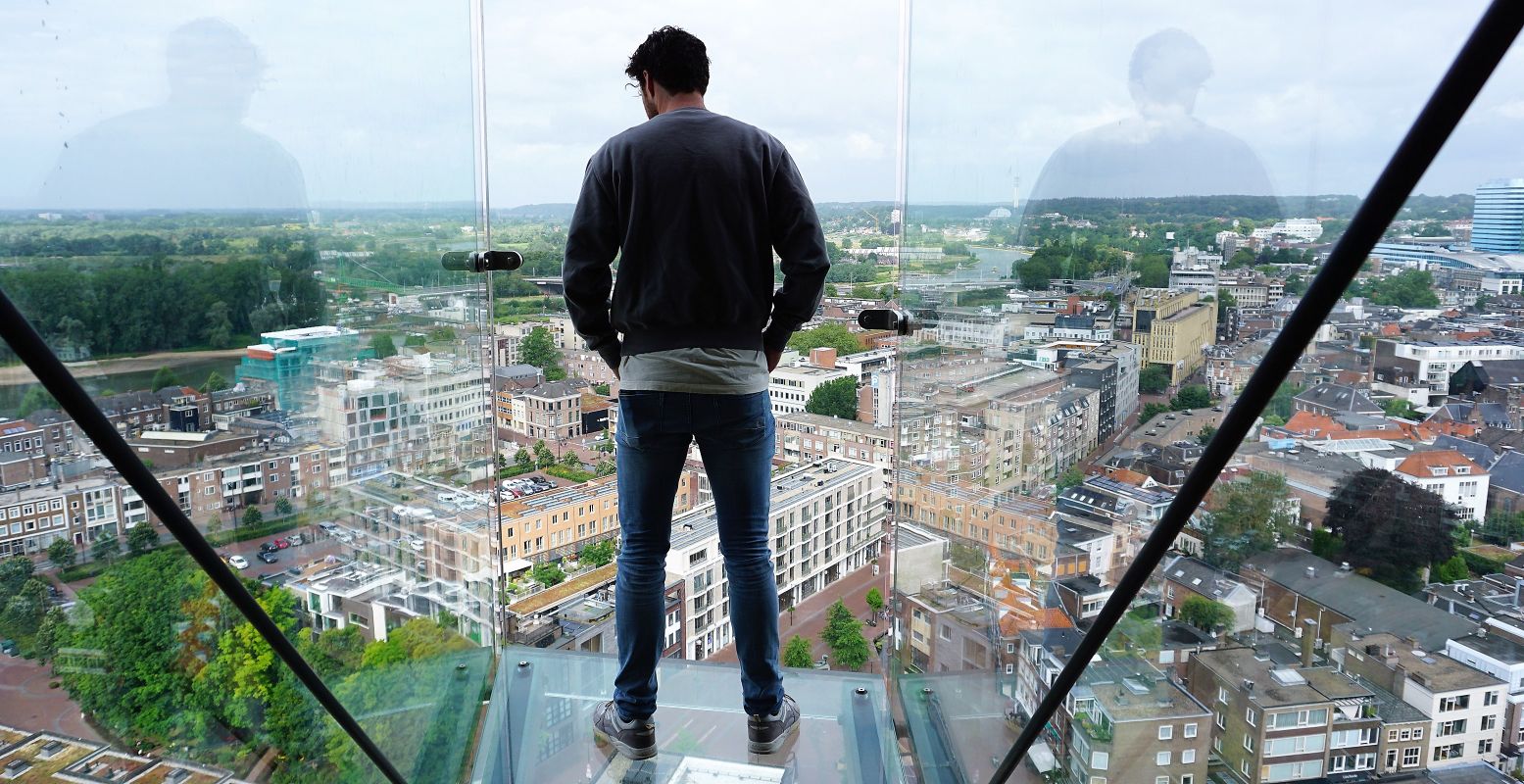 De glazen balkons zijn een belevenis: op 60 meter hoogte ligt Arnhem letterlijk onder je voeten. Foto: DagjeWeg.NL