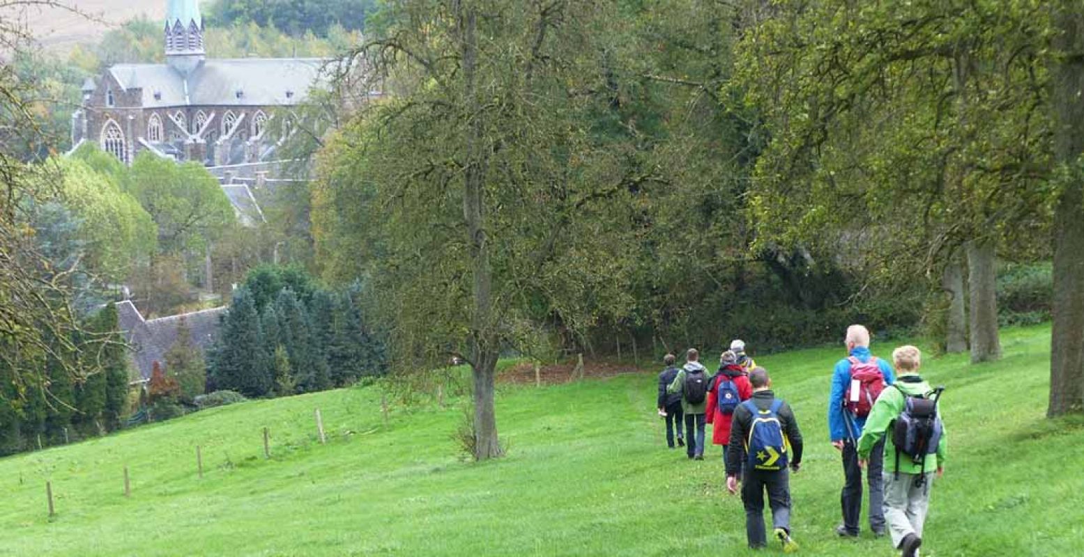 Wandelaars naderen abdij van Val-Dieu tijdens 'een wandeling rondom Zuid-Limburg'. Foto: Wandelroute van het Jaar 2018.