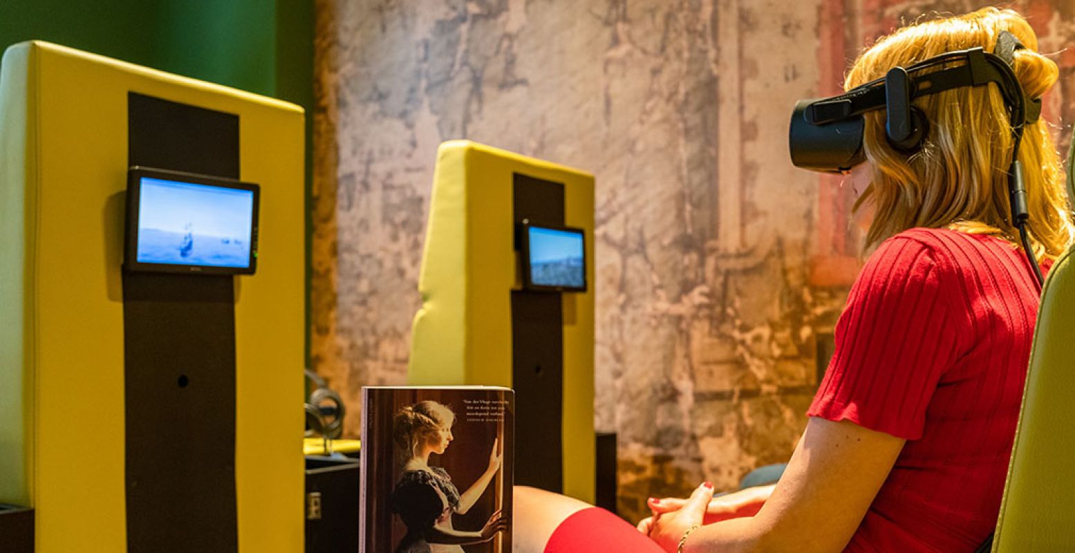 In de Virtual Reality zaal ruik je de geur van Asië, waardoor de VR beleving nog echter wordt. Simone van der Vlugt, schrijfster van het boek 'Het Schaduwspel', is een van de eersten die de VR reis uitprobeert. Foto: Westfries Museum