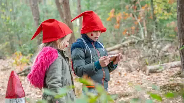 Een meisje met kaboutermuts en schmink op haar wangen in het bos | Foto ge&uuml;pload door gebruiker Staatsbosbeheer.