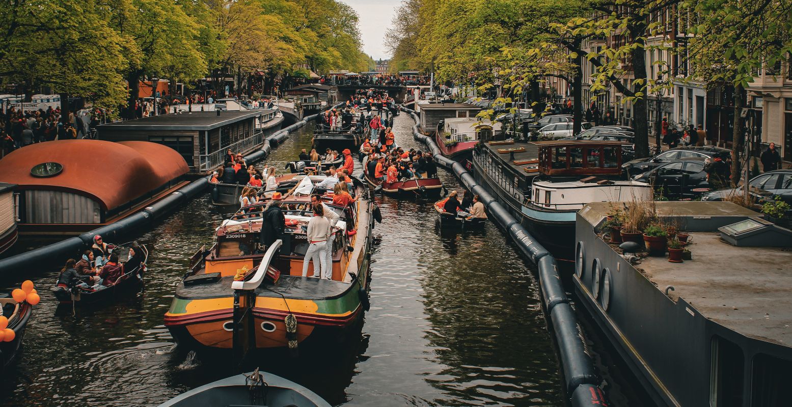 De grachten van Amsterdam liggen ook dit jaar weer vol met bootjes. Foto:  Abinash Satapathy  on  Unsplash 