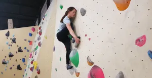 Op zoek naar een actief dagje uit? Ga boulderen! Nikki klimt geconcentreerd omhoog. Boulderen is een sport waarbij je je hele lijf traint. Het is ook een sociale sport en erg leuk om met een groep te doen. Foto: DagjeWeg.NL/Toli