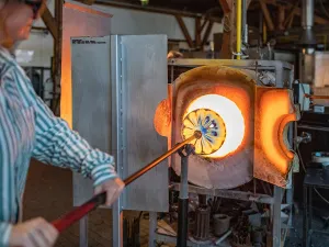 Het nog stroperige, hete glas wordt uit de oven gehaald. Foto: Glasblazerij Leerdam © BRANDRS