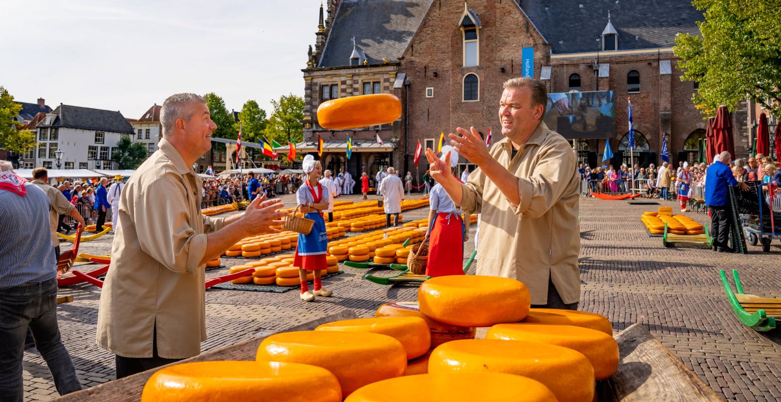 Zie de kaasdragers hard aan het werk op de Kaasmarkt in Alkmaar. Foto: Beeldbank Alkmaar © Ed van de Pol Zie de kaasdragers hard aan het werk op de Kaasmarkt in Alkmaar. Foto: Beeldbank Alkmaar © Ed van de Pol