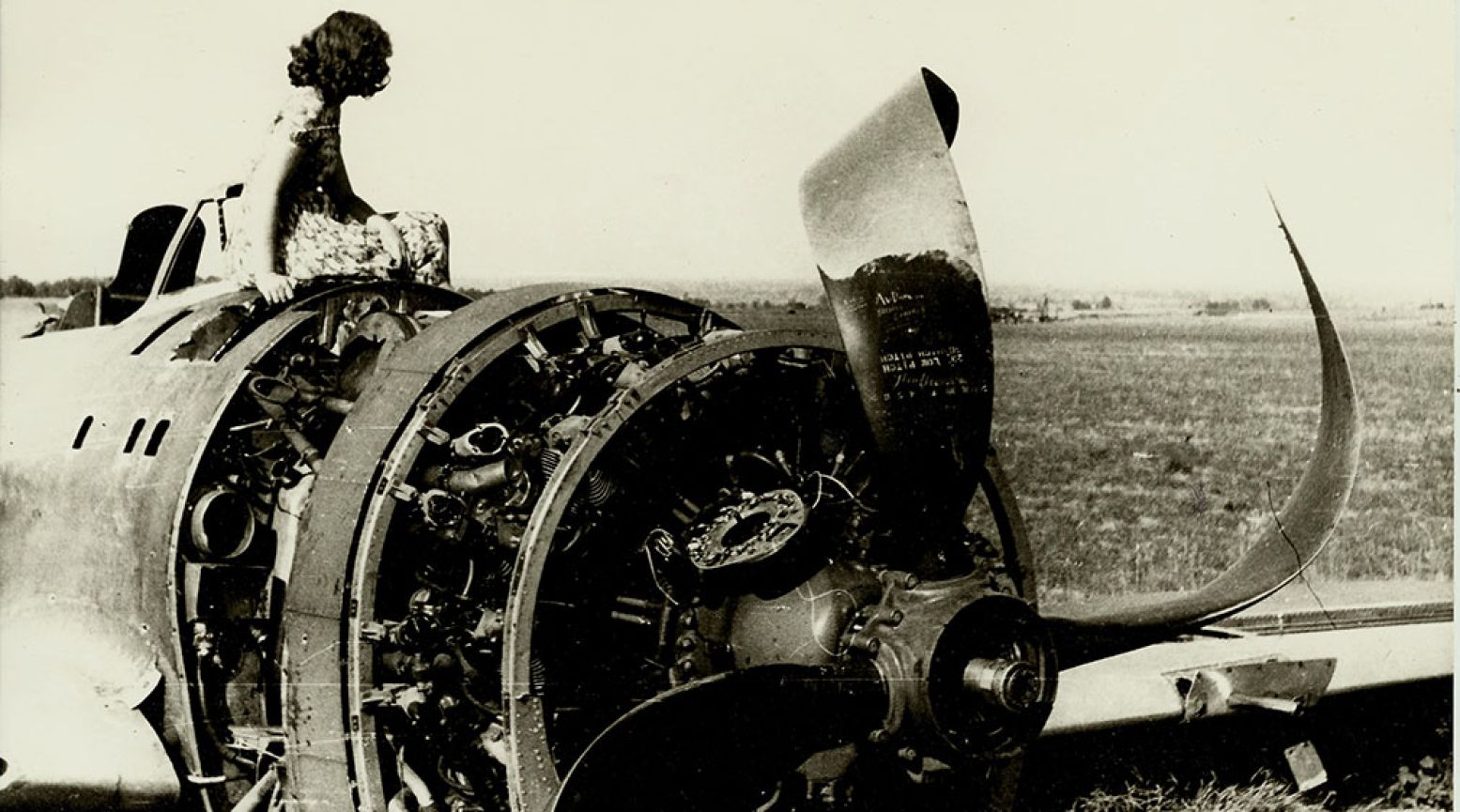 Een jong meisje zit op het wrak van een neergehaald Amerikaans gevechtsvliegtuig in een veld in de omgeving van Groesbeek. Een van de oorlogsbeelden die je tegenkomt in het Infocentrum. Foto: via Nationaal Bevrijdingsmuseum 1944-1945 Groesbeek
