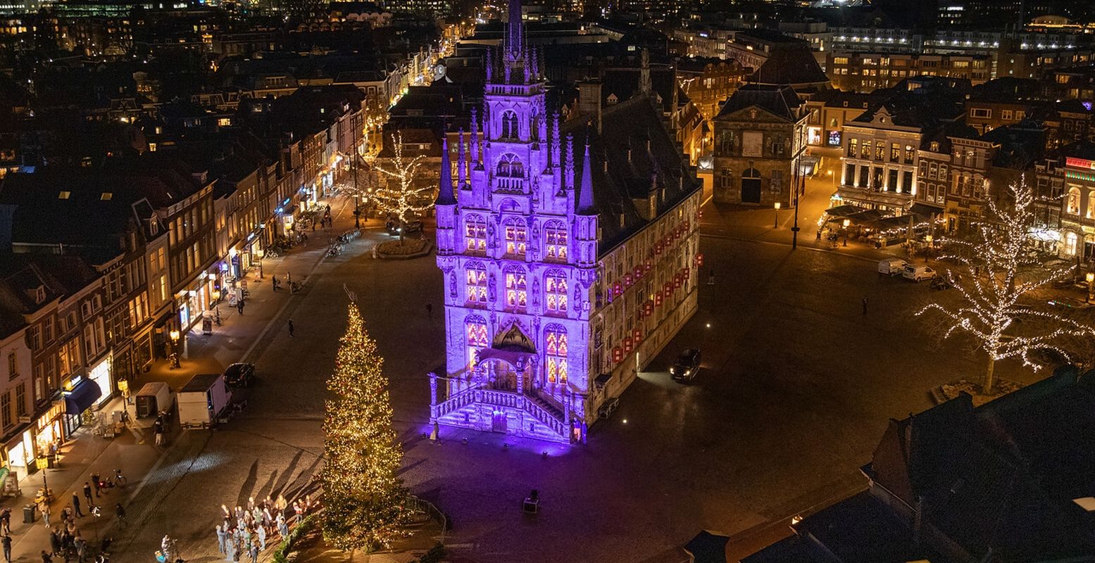 De enorme kerstboom voor het door kaarsjes verlichte stadhuis van Gouda. Reken dit jaar weer op een vol plein. Foto: Astrid de Haan