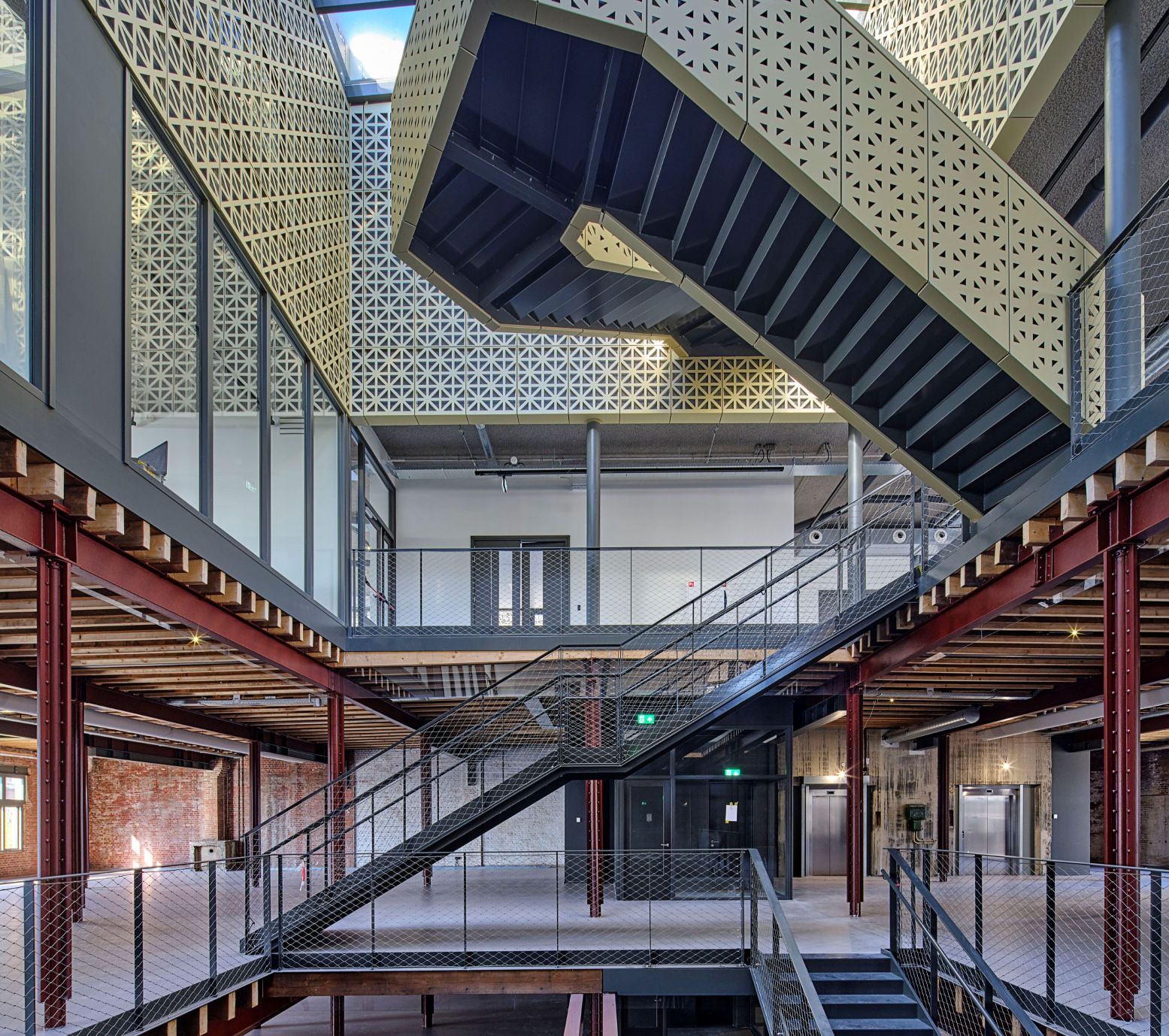 Door een glazen dak schijnt het daglicht helemaal naar beneden via een brede opening die door alle verdiepingen loopt. Stalen trappen zigzaggen hier omhoog en omlaag. Foto: Nederlands Fotomuseum perskit © Photo Studio Hans Wilschut Door een glazen dak schijnt het daglicht helemaal naar beneden via een brede opening die door alle verdiepingen loopt. Stalen trappen zigzaggen hier omhoog en omlaag. Foto: Nederlands Fotomuseum perskit © Photo Studio Hans Wilschut