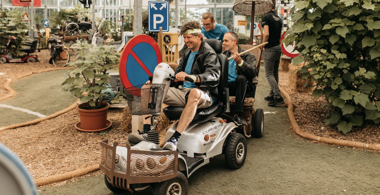 Wie van je collega's, vrienden of familieleden is het snelst in een scootmobiel? Foto: De Tuinderij