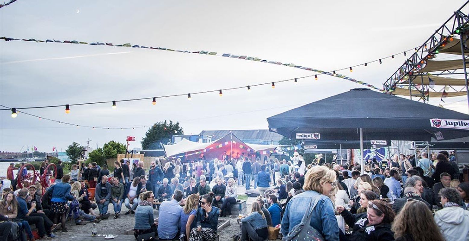 Geniet van een borrel en een snack aan de NDSM-werf in Amsterdam-Noord. Foto: Over het IJ.