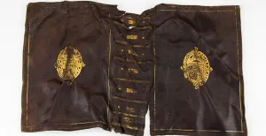 Bekijk extreem zeldzame kleding uit de Gouden Eeuw Een lederen boekkaft met daarop het wapen van de Engelse koninklijke familie Stuart. Foto: Kaap Skil.