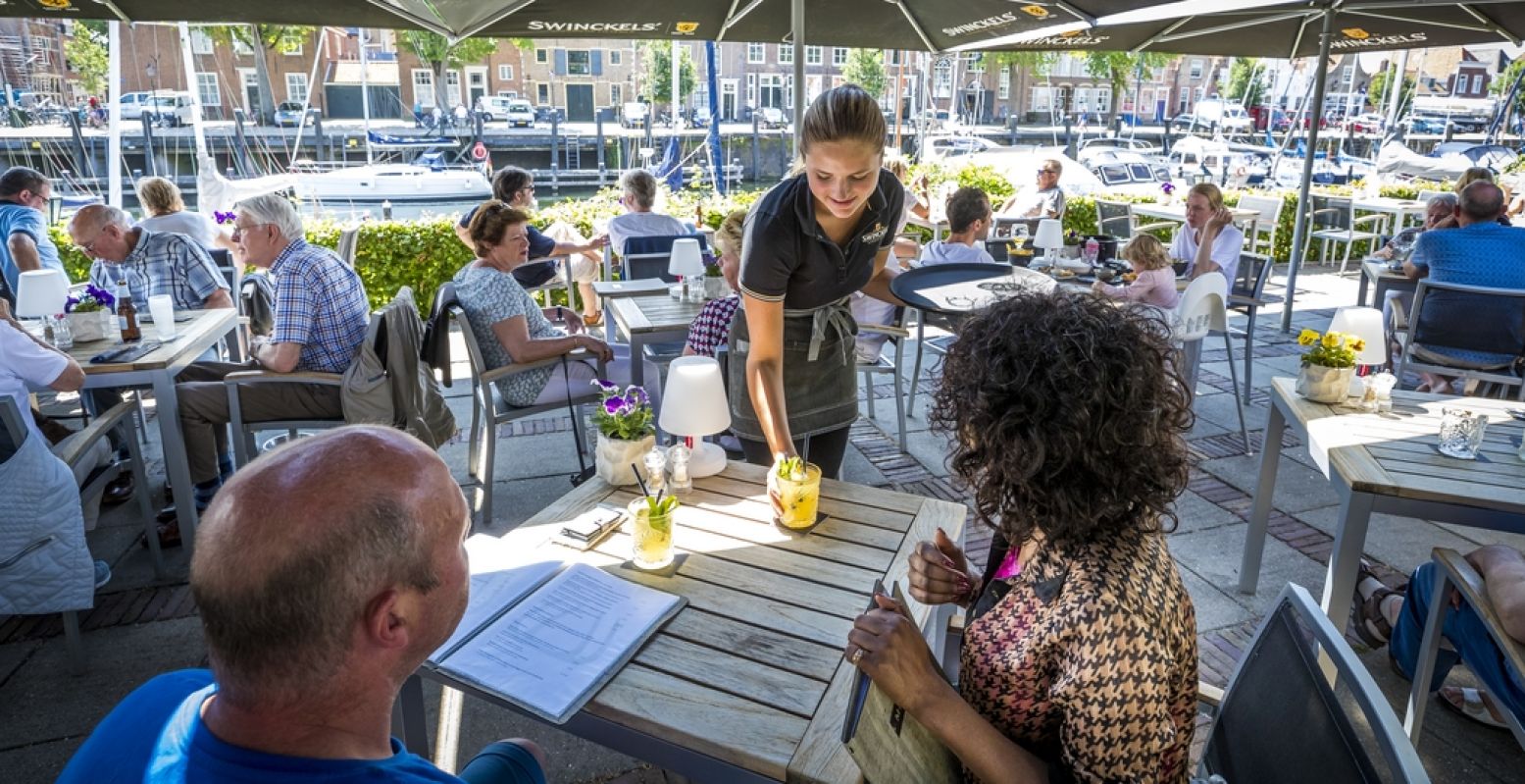 Vanaf het terras van Restaurant De Werf kijk je over het water naar de historische panden en de fraaie kerk van Veere. Foto: Restaurant De Werf © Marcel van Hoorn