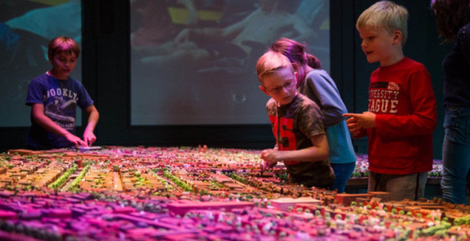 Kinderen bewonderen Amsterdam in het klein bij Museum Het Grachtenhuis.