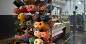 Toveren met stof in het Textielmuseum Per maand gaat er 3000 kilo garen doorheen in het bedrijvige Textielmuseum. Foto: DagjeWeg.NL