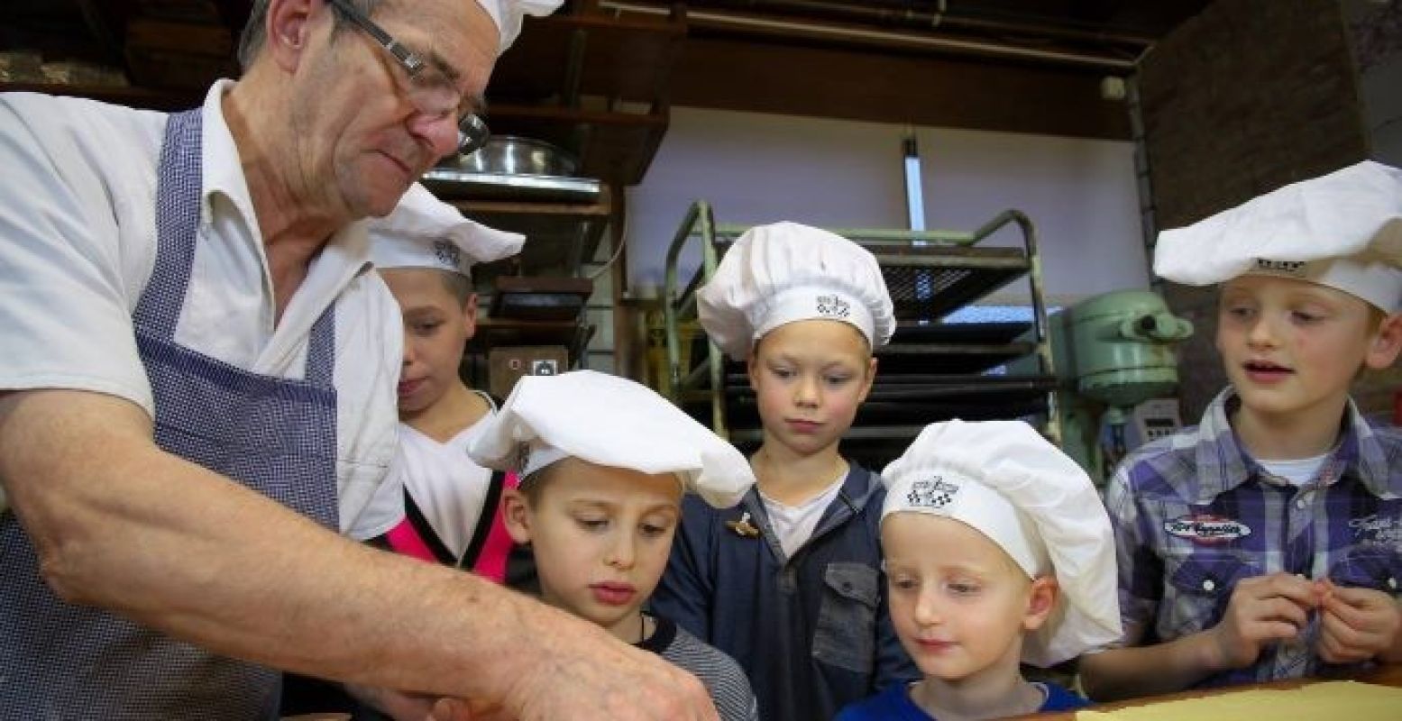 Wie wil de bakker helpen? Foto: Bakkerijmuseum De Oude Bakkerij Wie wil de bakker helpen? Foto: Bakkerijmuseum De Oude Bakkerij
