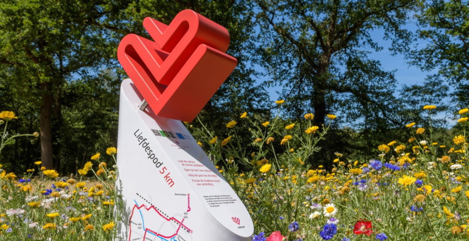 Informatiezuil tussen de bloemen langs het romantische Liefdespad in Ruurlo. Foto: Het Liefdespad.