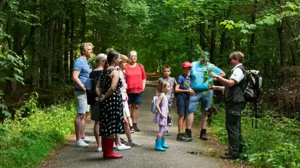 Boswachter in het bos met plant in handen voor een gezin | Foto ge&uuml;pload door gebruiker Staatsbosbeheer.