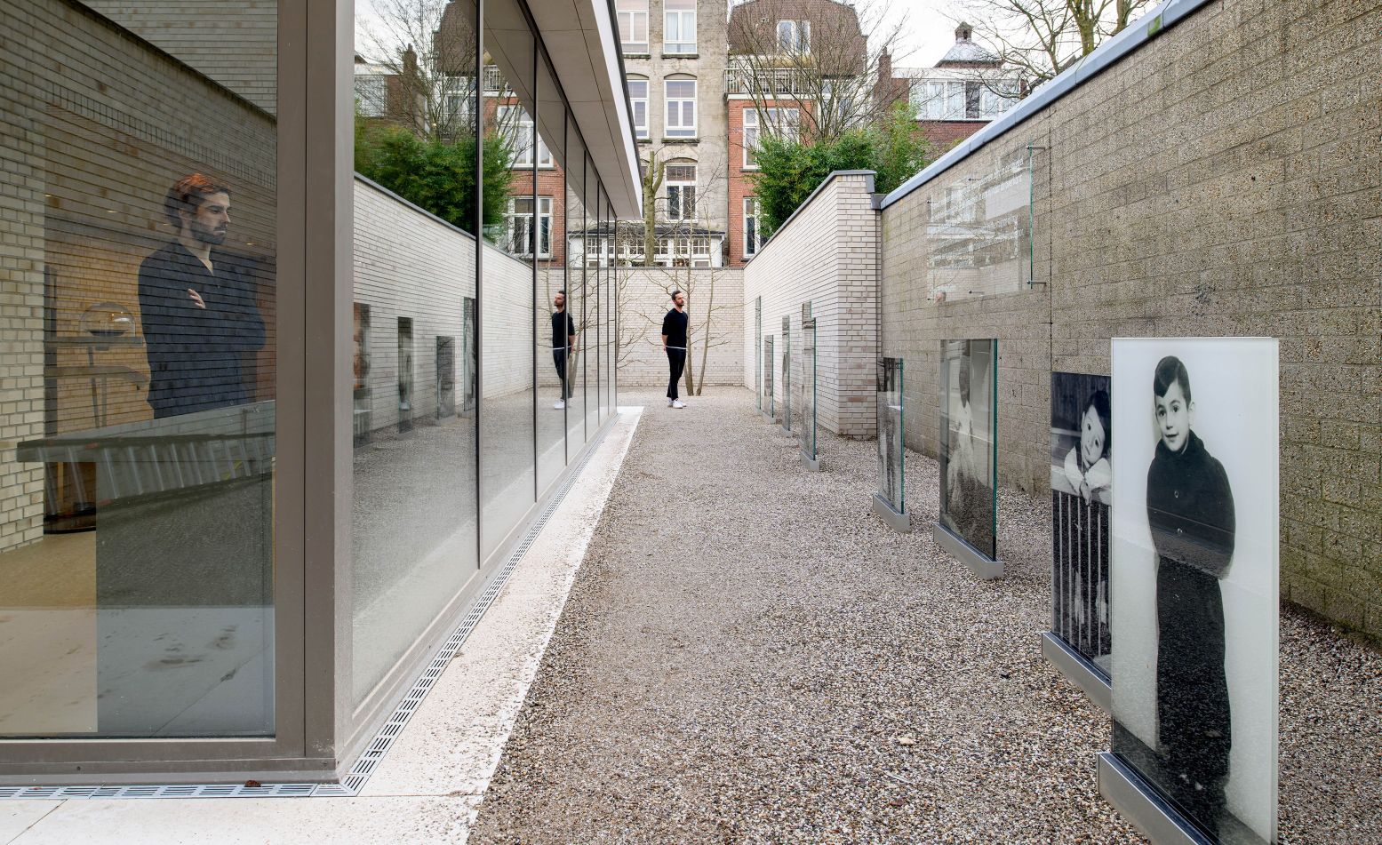 De erfafscheiding tussen de voormalige kweekschool en crèche in het Nationaal Holocaustmuseum. De afgebeelde kinderen en directrice Henriëtte Pimentel werden gedeporteerd en vermoord. Foto: Joods Cultureel Kwartier © Mike Bink