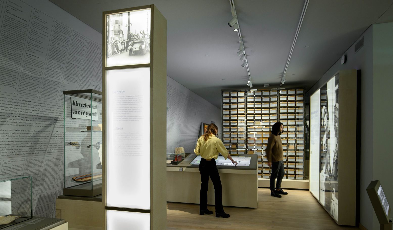 Zaal uit het Nationaal Holocaustmuseum met achterin de Cartotheek van de Joodse Raad en links het misdadenbehang. Foto: Joods Cultureel Kwartier © Mike Bink