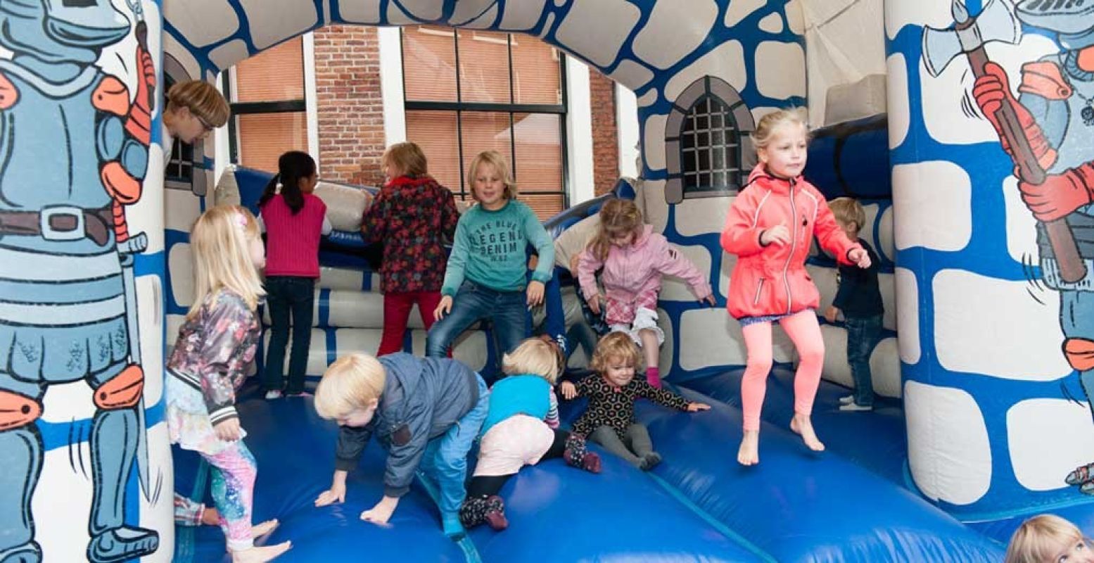 De kids springen vrolijk rond op het springkussen op het Kinderplein. Foto: Hans van den Berg.