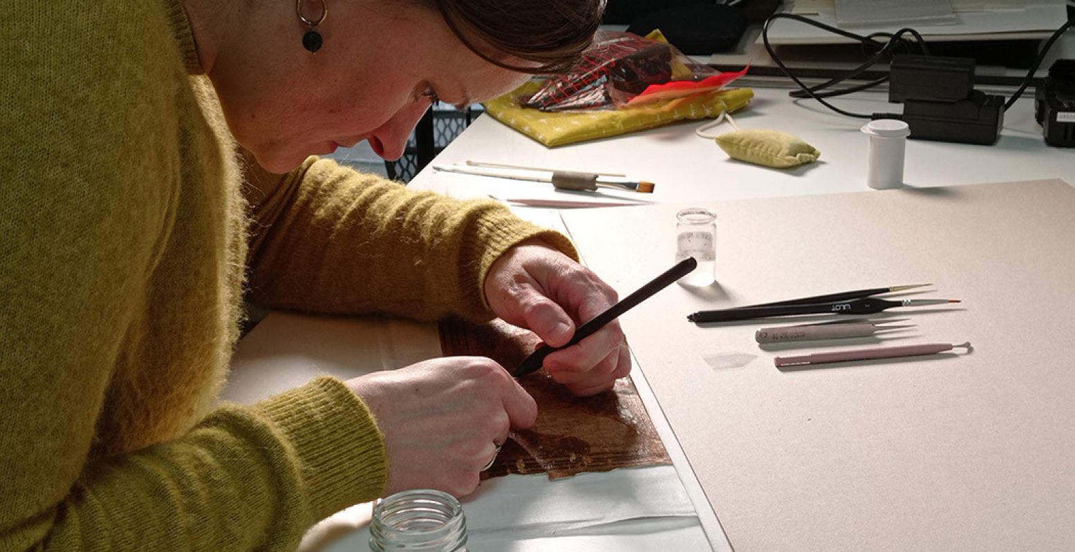 Restaurator Eliza Jacobi aan het werk. Na vier jaar zorgvuldig restaureren is de papyrus van Qenna voor het eerst in zijn geheel te zien. Foto: Rijksmuseum van Oudheden