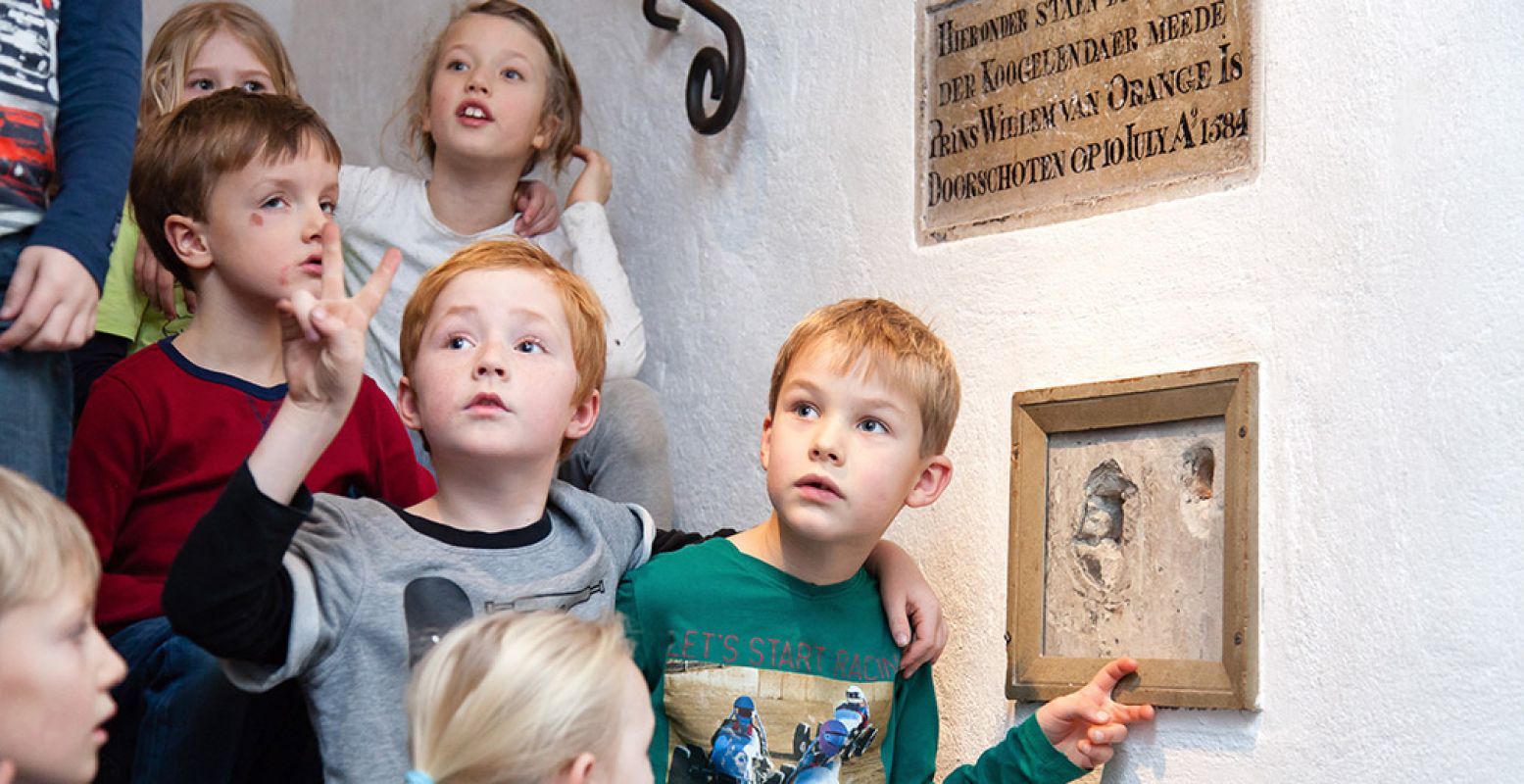 Kinderen bij de kogelgaten in Museum Prinsenhof Delft. Foto: Museum Prinsenhof Delft