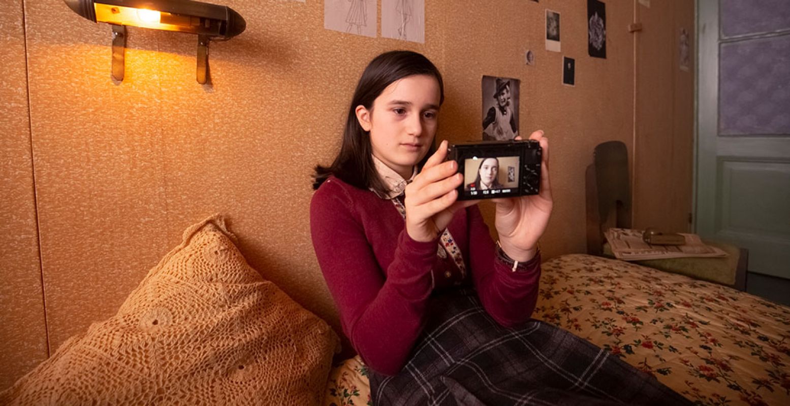 Anne Frank (gespeeld door de dertienjarige Luna Cruz Perez) in het Achterhuis met haar camera. Je kunt haar vlogs zien in de YouTube serie Anne Frank videodagboek. Foto: copyright Anne Frank Huis, fotograaf Ray van der Bas