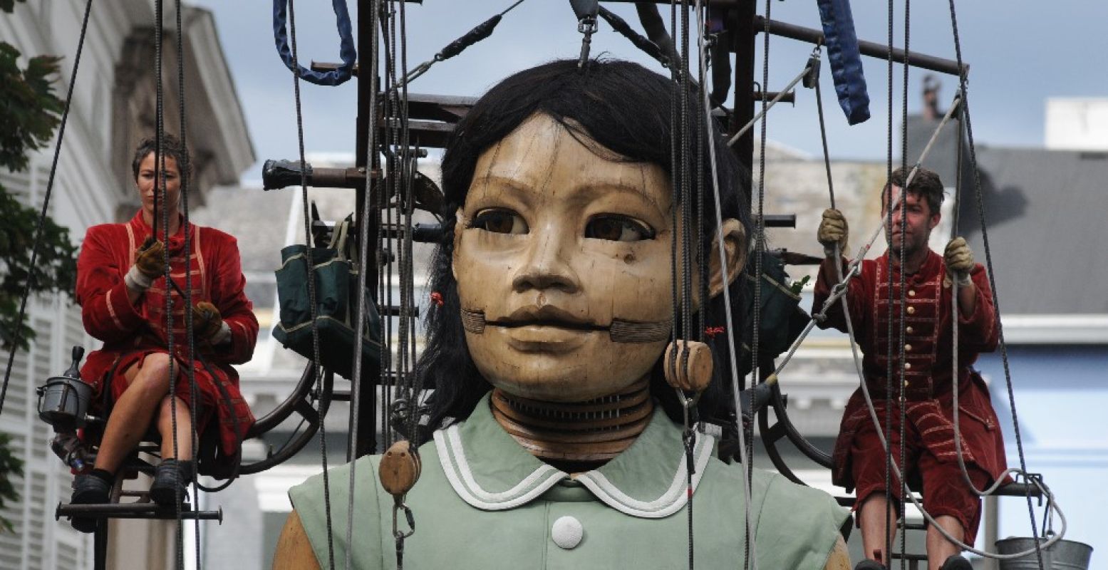 Het Kleine Reuze Meisje draagt de ene keer een groene jurk, dan weer een roze. Foto: © Royal de Luxe _ Artcompress _ Pascal Victor