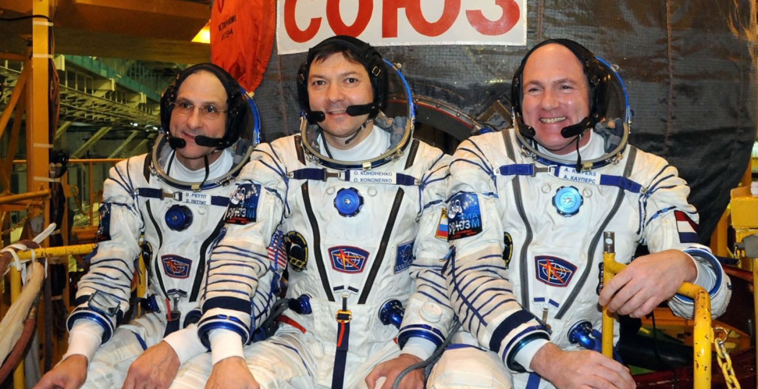 Van links naar rechts Don Pettit, Oleg Kononenko en André Kuipers voor hun lancering in 2011. Door NASA -  http://spaceflight.nasa.gov/gallery/images/station/crew-30/html/jsc2011e215512.html , Publiek domein,  https://commons.wikimedia.org/w/index.php?curid=17632997 