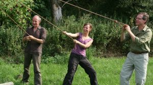Twee mannen en een vrouw lachen tijdens touwtrekken bij de survival Foto: Outdoorpark SEC Almere