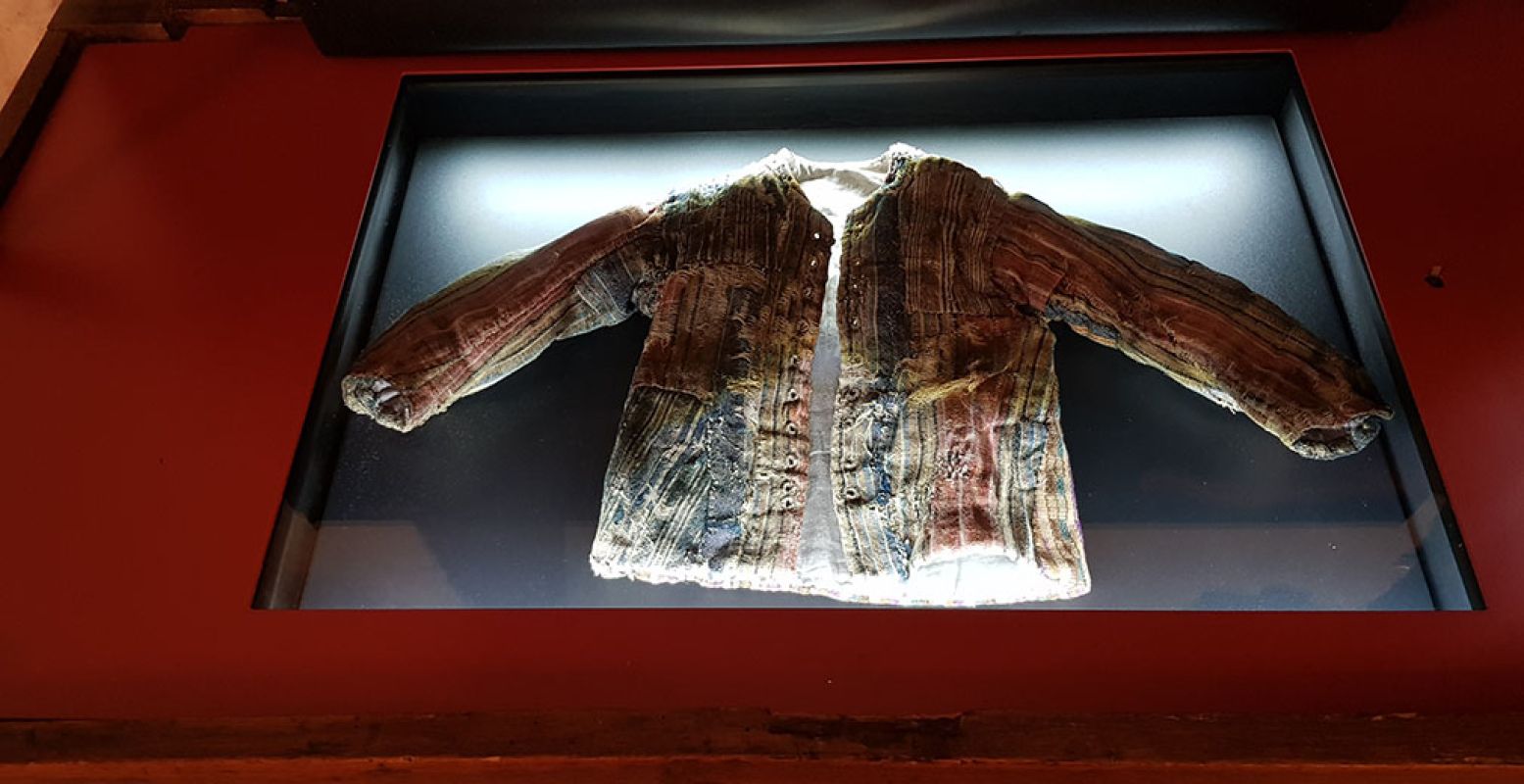 Pronkstuk van de Gevangenpoort: een kinderjasje uit de achttiende eeuw dat bij een restauratie werd gevonden. Gepropt in een tochtgat. Foto: DagjeWeg.NL / Tonny van Oosten