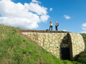 Waterliniepad: 350 kilometer forten,vestingstadjes en natuur Wandelaars bij de beschilderde bunker aan de Diefdijk. Foto: Wandelnet © Ad Snelderwaard