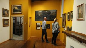 Man en vrouw bekijken schilderijen in Voerman Museum