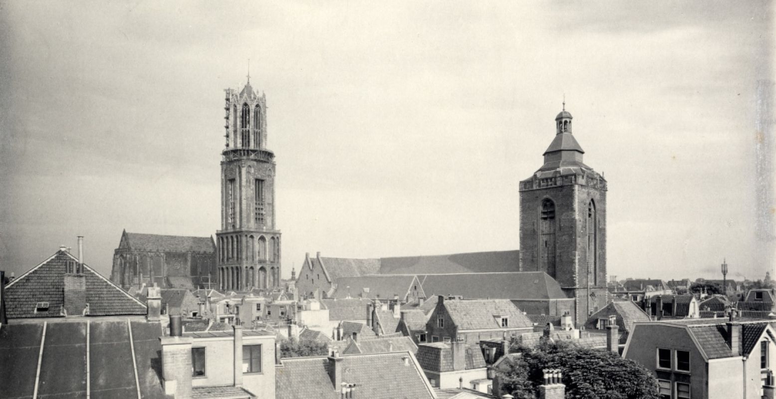 Gezicht op de Buurkerk vanaf het dak van het huis Oudegracht 147; links de Domtoren, rechts de Buurkerk en in het midden de achtergevels van de huizen aan de Steenweg. Foto: Museum Speelklok, W.G. Bear, 1909. Utrechts Archief.