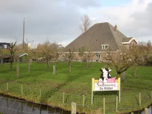 Kinderboerderij De Ridder Achter de vruchtbomen ligt de oude stolpboerderij. Foto: DagjeWeg.NL