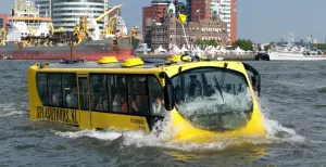 12 dagjes weg met mooi weer Duik met bus en al de Maas in en bewonder de mooiste hotspots van Rotterdam. Foto: Splashtours Rotterdam.