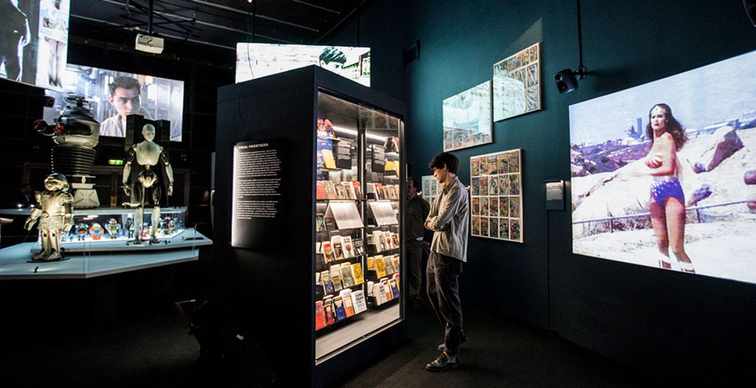 Een deel van de expositie, met de robot Sonny links. Op het scherm rechts zie je Wonder Woman in actie. Foto: Tristan Fewings / Getty Images, bijgesneden voor DagjeWeg.NL