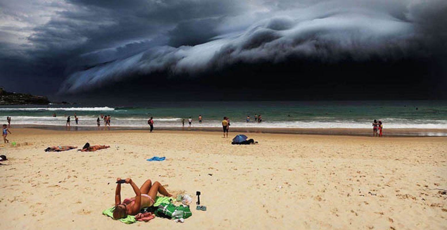 Nature, 1st prize singles. Rohan Kelly, Australia, 2015, Daily Telegraph, Storm Front on Bondi Beach. A massive 'cloud tsunami' looms over Sydney as a sunbather reads, oblivious to the approaching cloud on Bondi Beach, Sydney, Australia on 06 November 2015.
