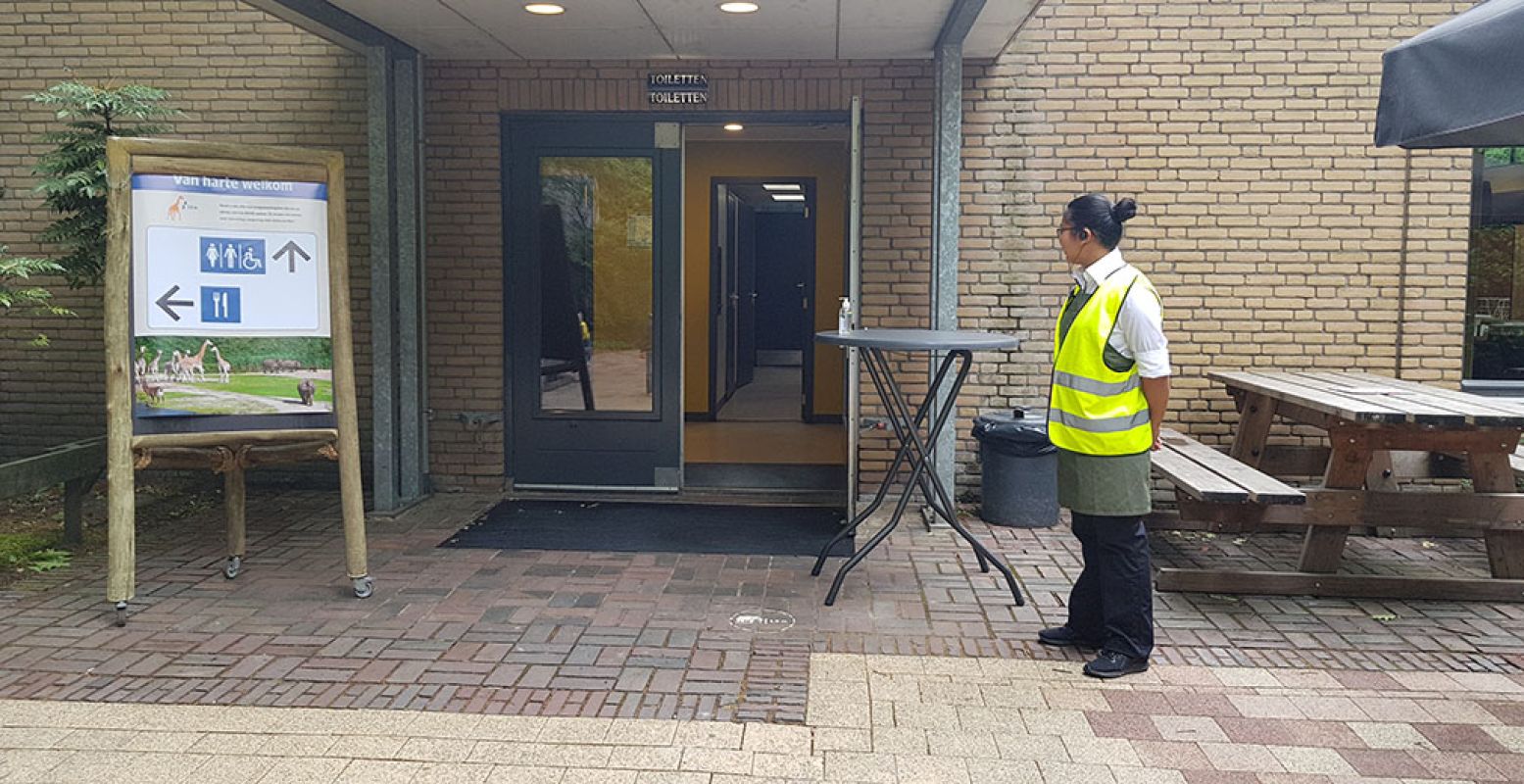 Ook bij de toiletten wacht je buiten. Een medewerker houdt in de gaten hoeveel mensen binnen zijn en laat je weten of je naar binnen kunt. Foto: DagjeWeg.NL