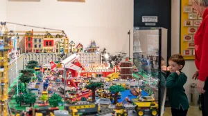 Jongetje bekijkt een grote stad gebouwd van Lego in Museum van de 20e eeuw. Foto: Foto: Benno Ellerbroek / Museum van de Twintigste Eeuw