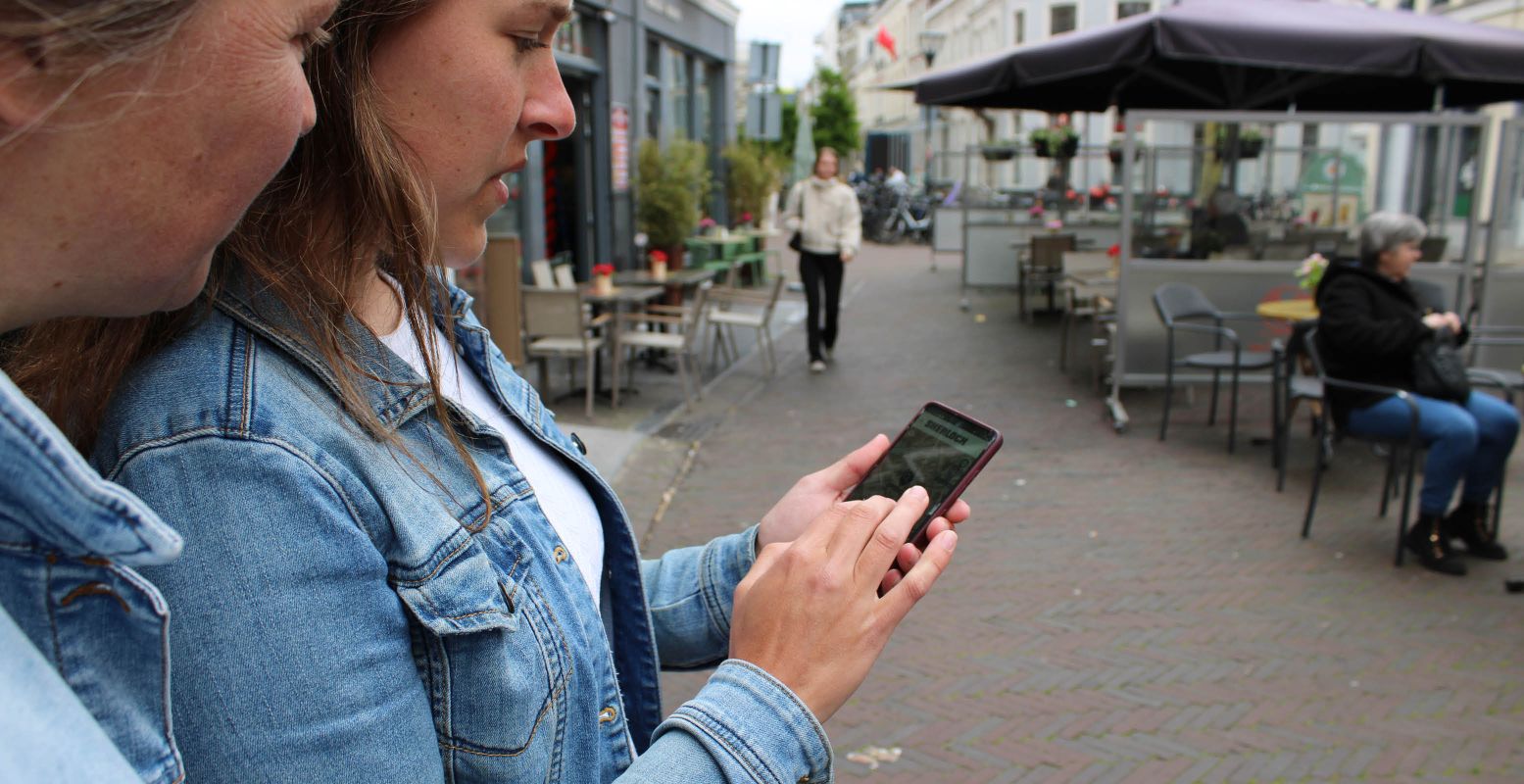 Zoek een bankje om te kletsen met een lid van de wandelclub van één van de verdachten. Scan het bankje en je kunt weer door! Foto: DagjeWeg.NL