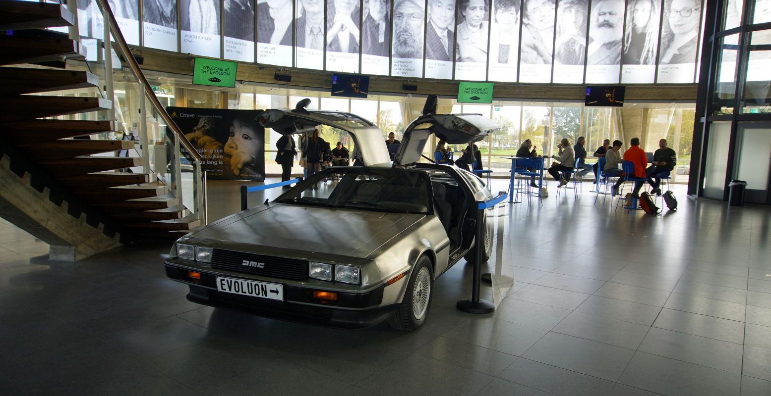 De DeLorean, de tijdmachine uit de film Back to the Future, staat binnen al te wachten. Aan de muur is een hele cirkel van denkers over de toekomst te zien. Foto: DagjeWeg.NL © Tonny van Oosten