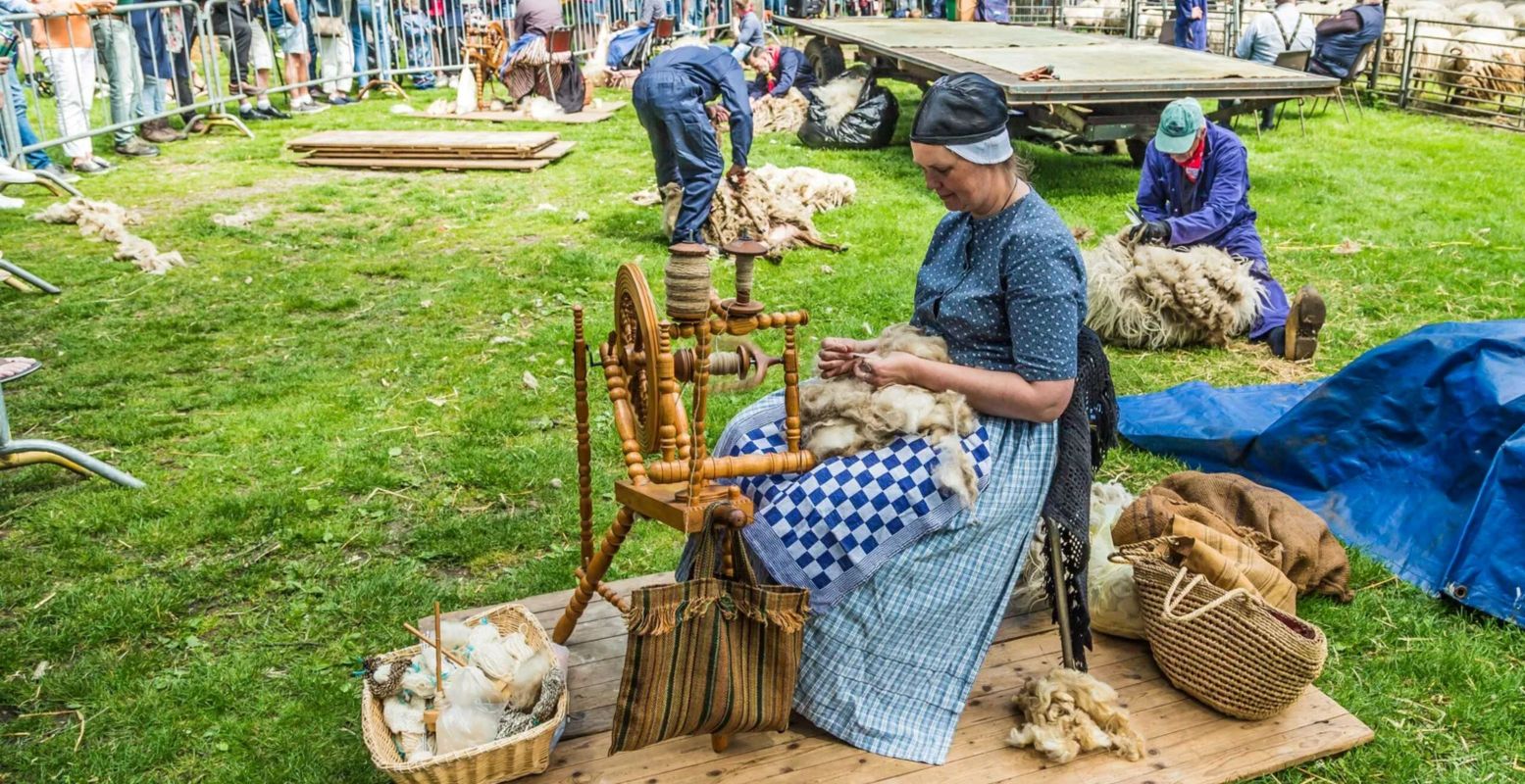 Op het schaapscheerdersfeest in Exloo vind je ook wolspinsters in leuke, ouderwetse klederdracht. Foto: © Bram van Wijk