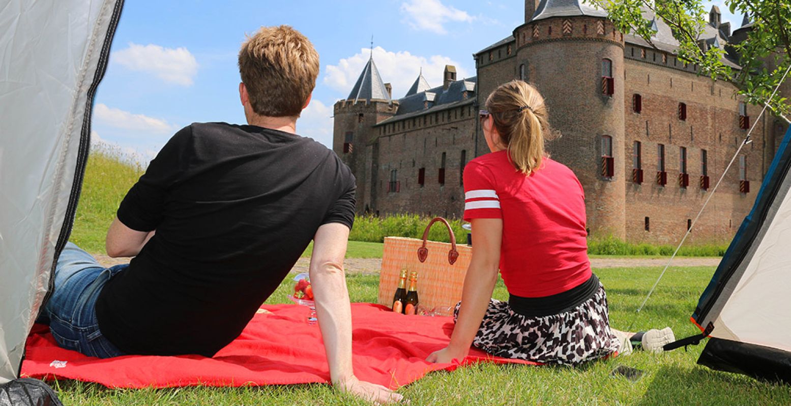 Dit jaar kun je een nachtje kamperen in de pruimenboomgaard bij het Muiderslot. Met uitzicht op het mooie middeleeuwse kasteel. Foto: Muiderslot