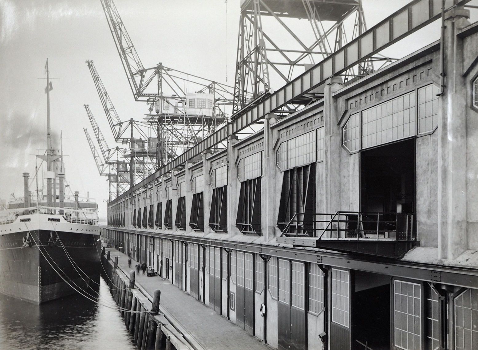 Een schip ligt bijna een eeuw geleden aangemeerd voor de enorme havenloods, waar nu kunstmuseum Fenix in huist. Foto: Stadsarchief Rotterdam via de perskit van Fenix Een schip ligt bijna een eeuw geleden aangemeerd voor de enorme havenloods, waar nu kunstmuseum Fenix in huist. Foto: Stadsarchief Rotterdam via de perskit van Fenix