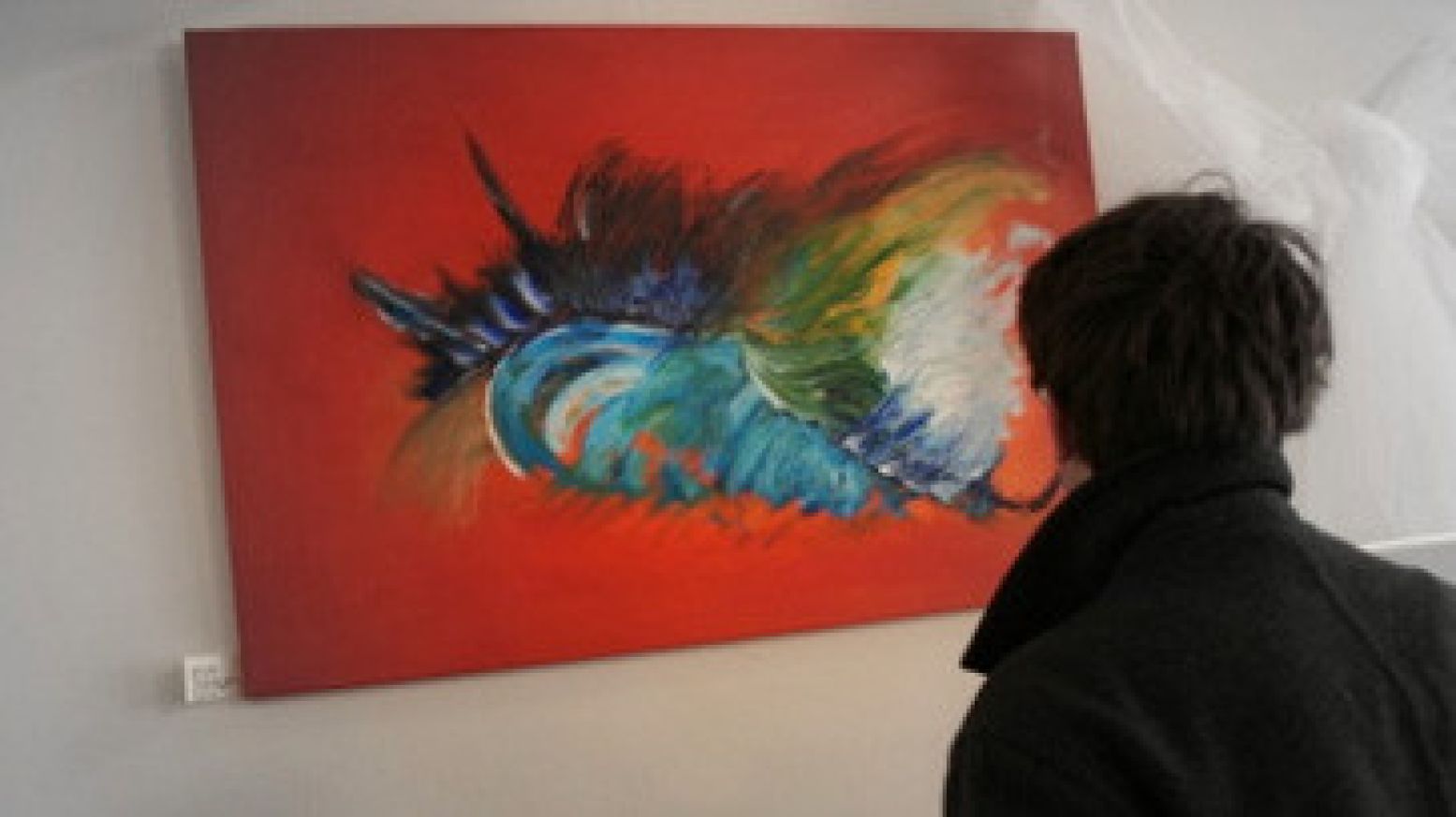 Een bezoeker bewondert het doek Bird on Red van modern kunstenaar Thea Benschop-Houdijk. Foto: Caroline de Vente.