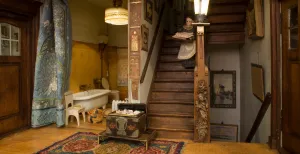 Beroemd Haags poppenhuis Lita de Ranitz weer te zien Bediendes, prachtig houtsnijwerk op de trap, elektrische lampen en zelfs een badkamer met stromend water! Alles straalt rijkdom uit. Foto: Haags Historisch Museum