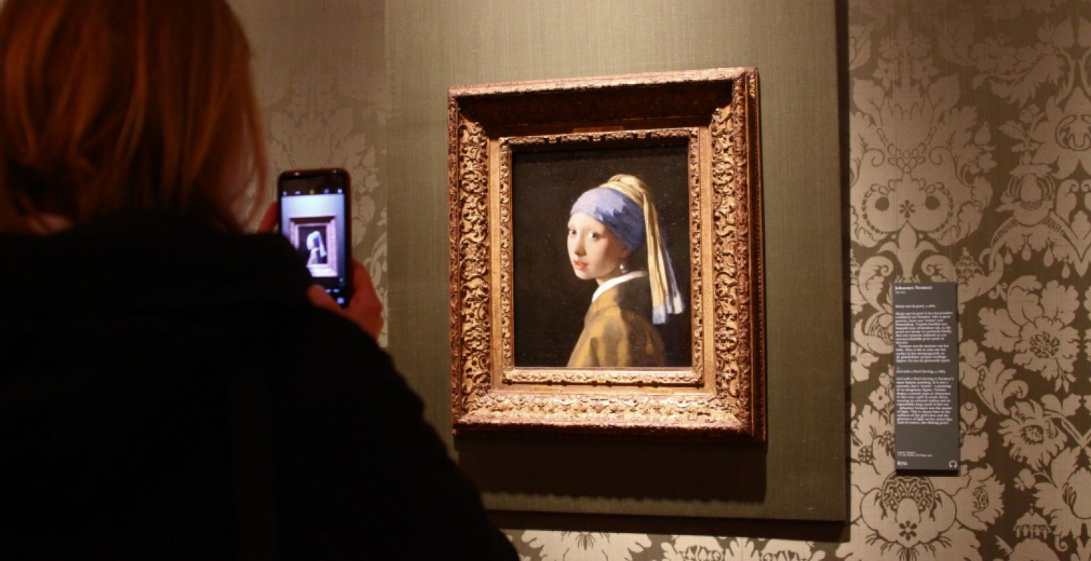 Vrouw maakt foto van Meisje met de parel in het Mauritshuis. Foto: DagjeWeg.NL.