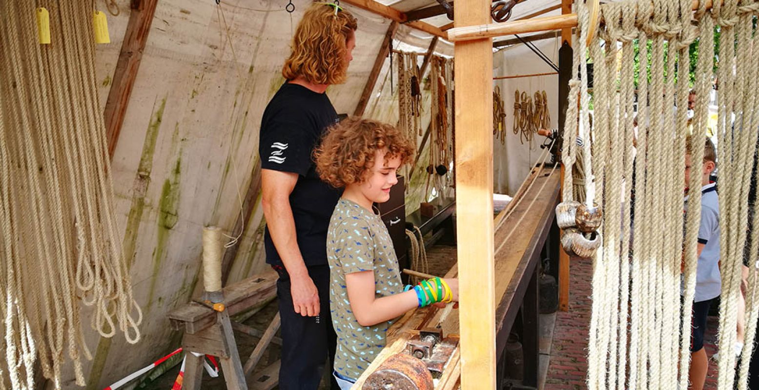 Help ambachtslieden een handje mee, zoals hier bij de touwslagerij. Foto: DagjeWeg.NL.