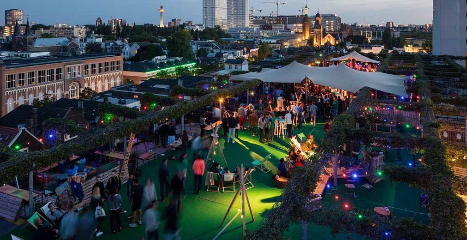 Een rooftop feestje met de Rotterdamse skyline op de achtergrond. Foto: Ossip van Duivenbode